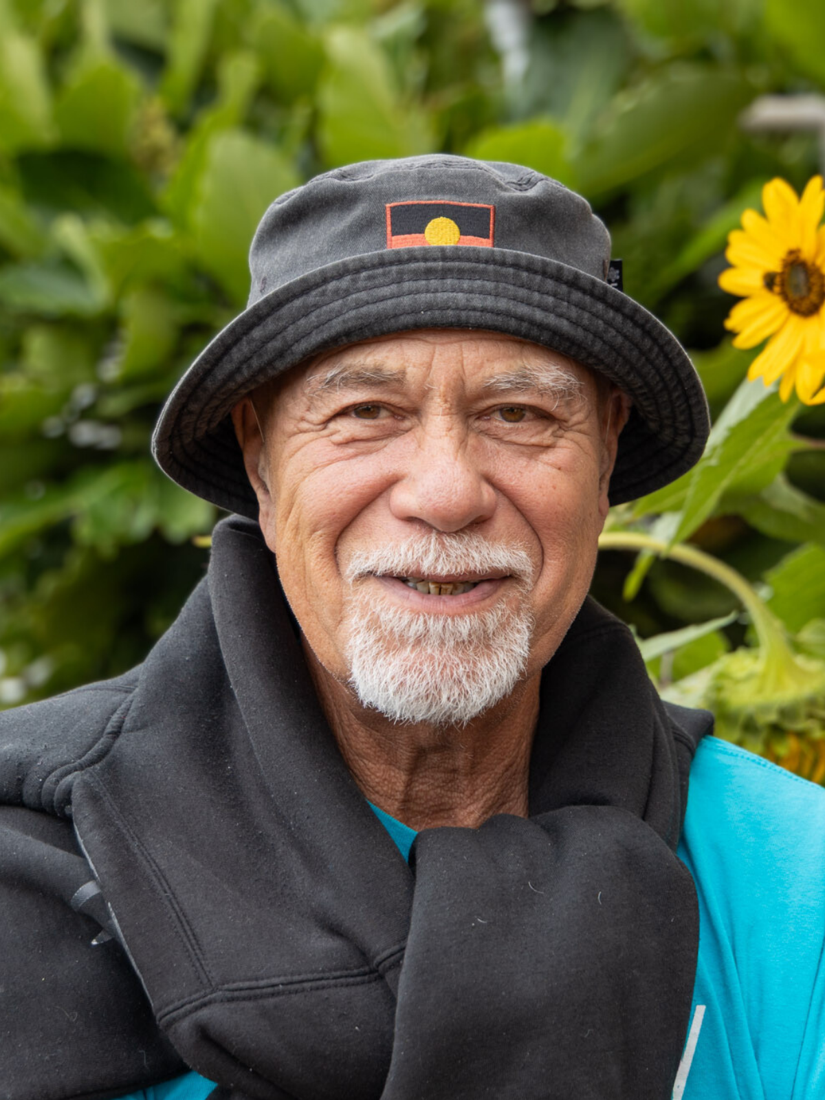Denis Grennell smiling outdoors in soft natural light.